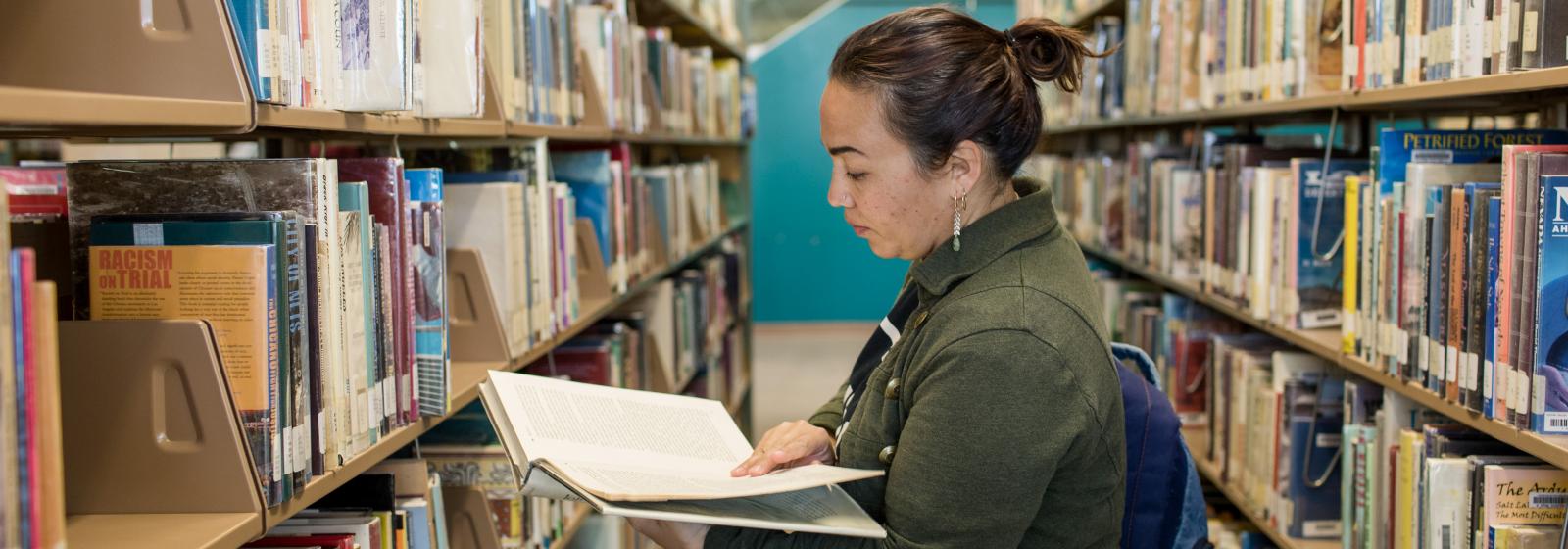 Woman reading book in library