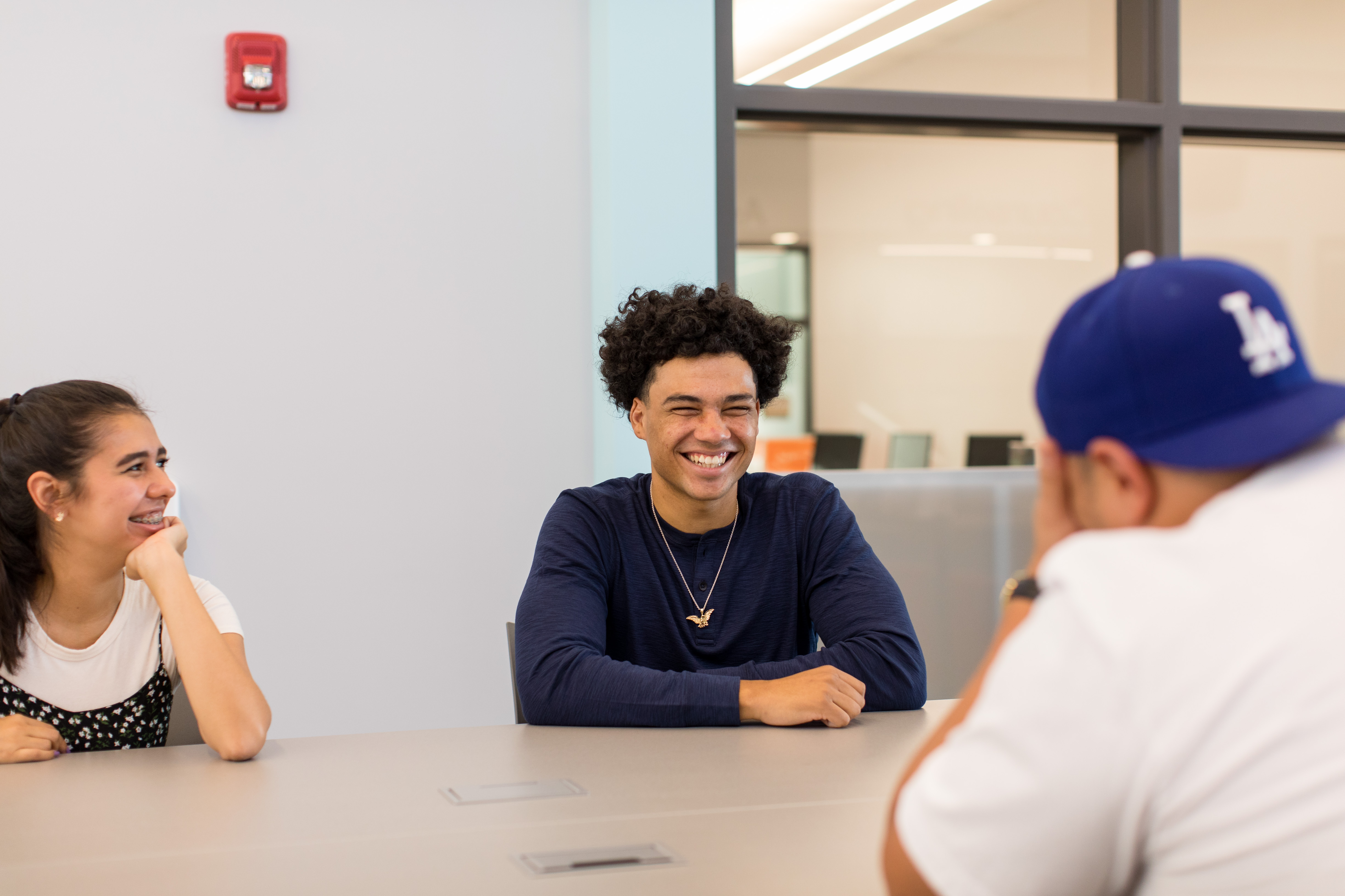 Thee students sitting at a table and talking
