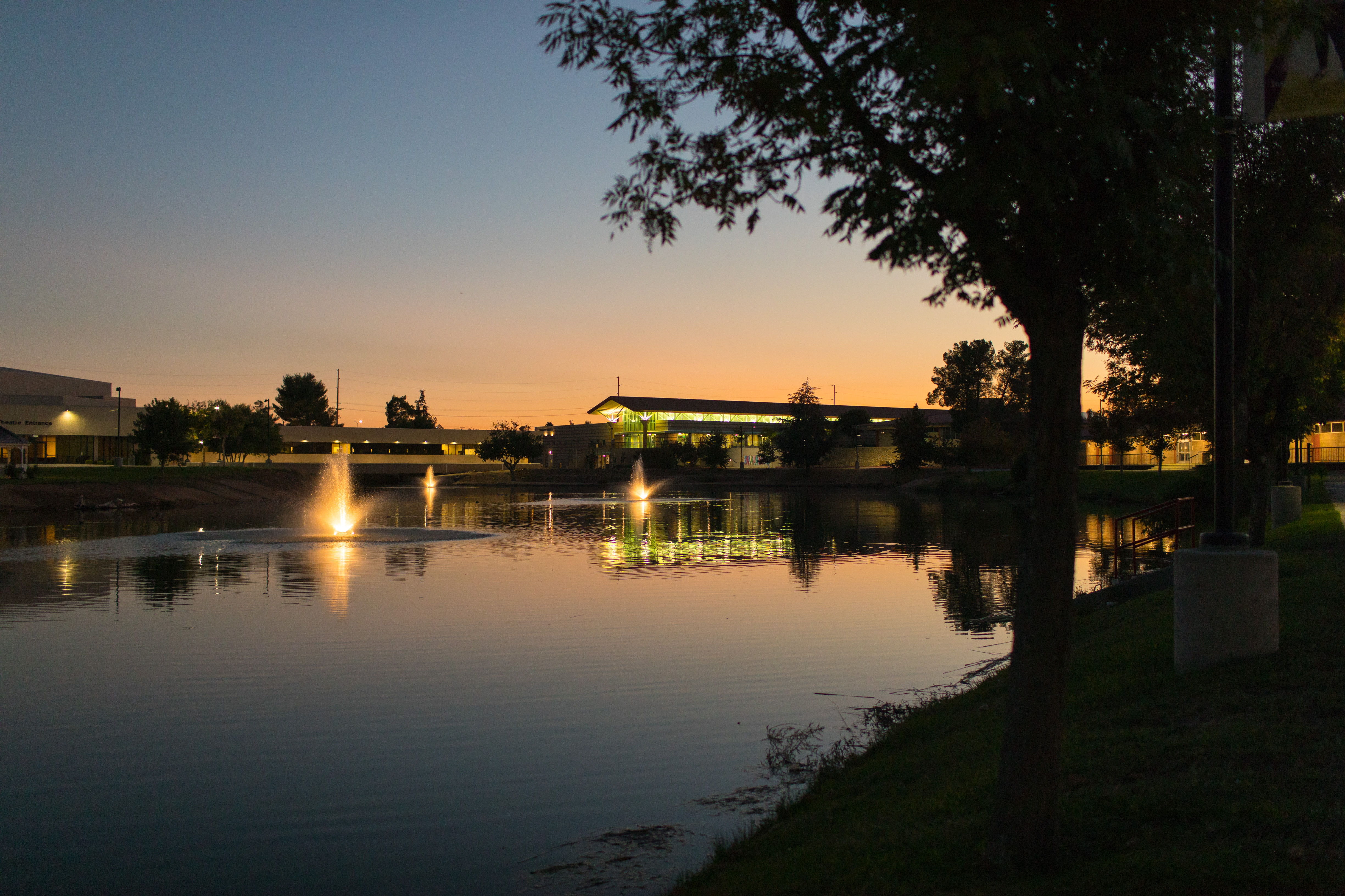 VVC campus lake at dusk with buildings in the background.
