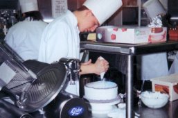 FrostingTheCake.jpg 1999 restaurant management club booth at tech fair 1999